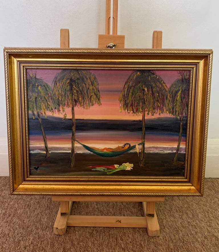 Framed oil painting of a tropical sunset beach scene with palm trees, hammock, and calm ocean waters on wooden easel