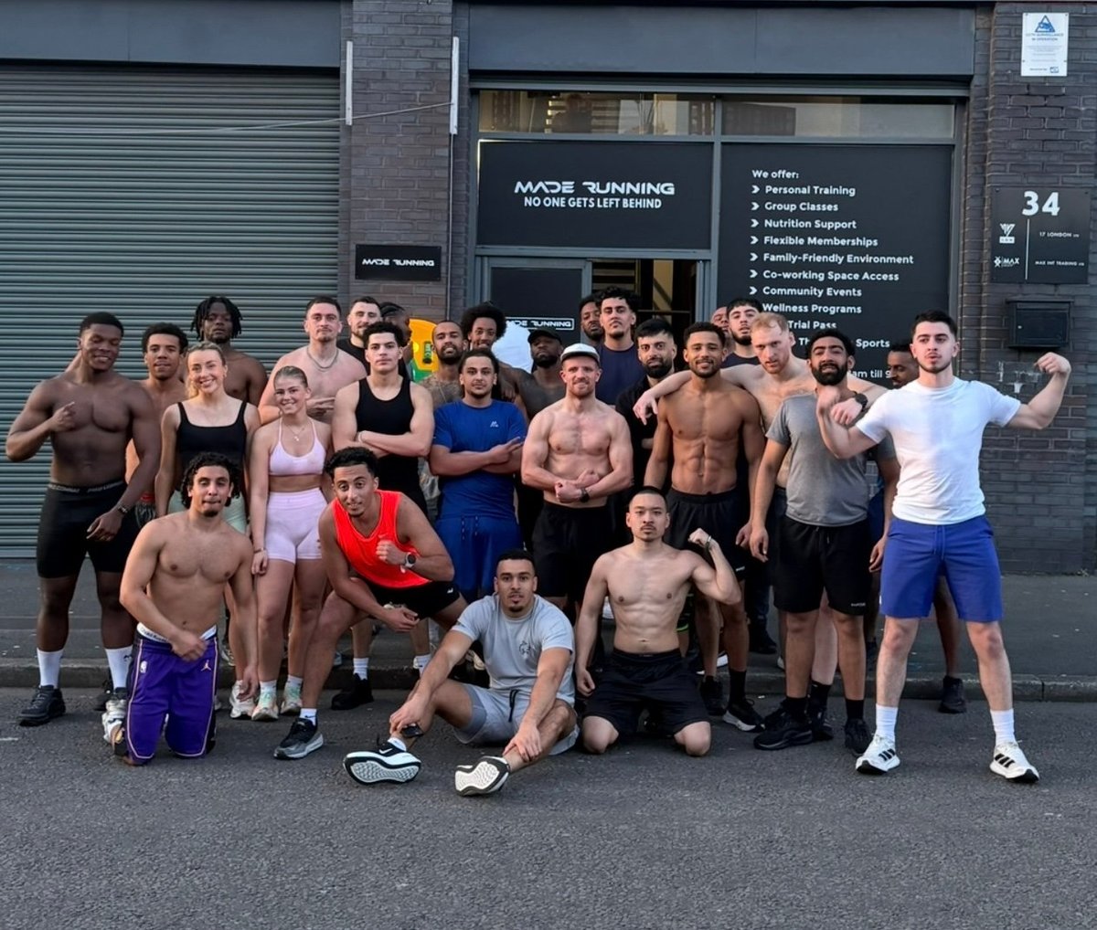 Group of fitness enthusiasts posing outside a gym