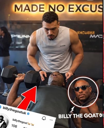 Man in gray tank top doing dumbbell exercise at gym with MADE NO EXCUSES sign behind him, Billy the GOAT inset