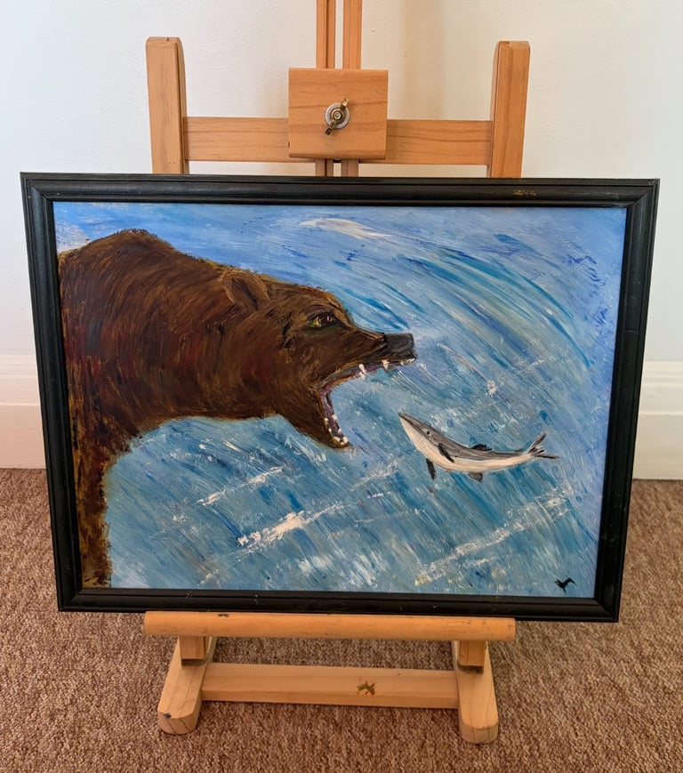 Oil painting of a brown bear fishing for salmon in blue water, displayed on a wooden easel
