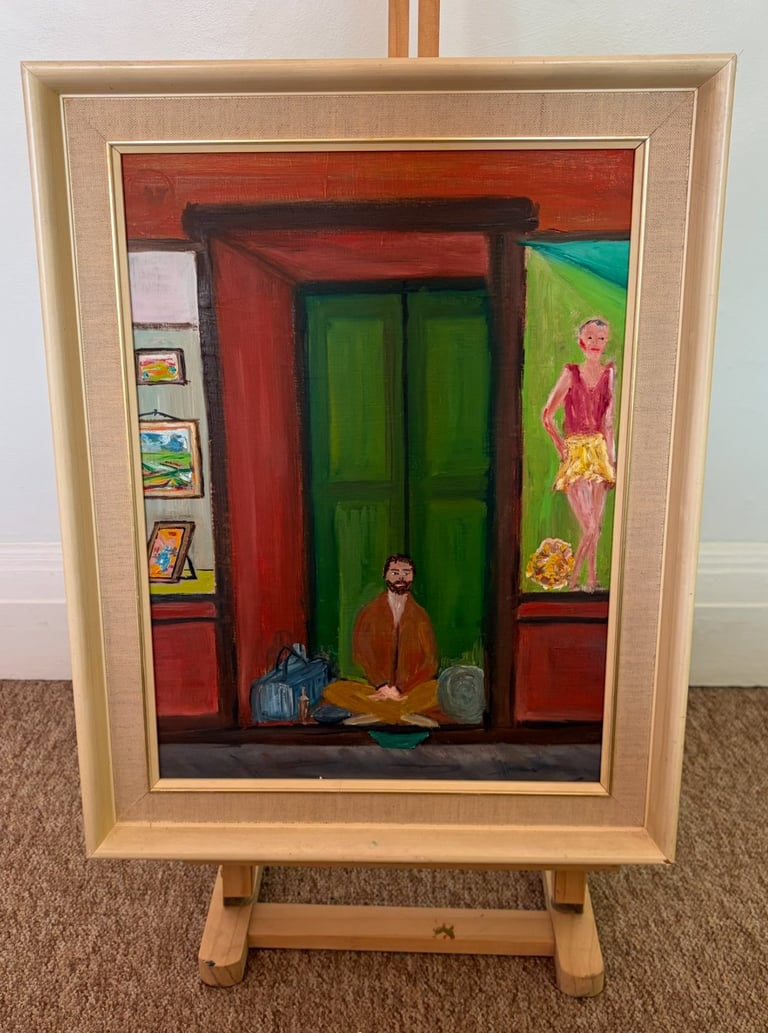 Framed painting on wooden easel depicting a figure sitting in a green doorway with red walls, storefronts, and a woman poster visible