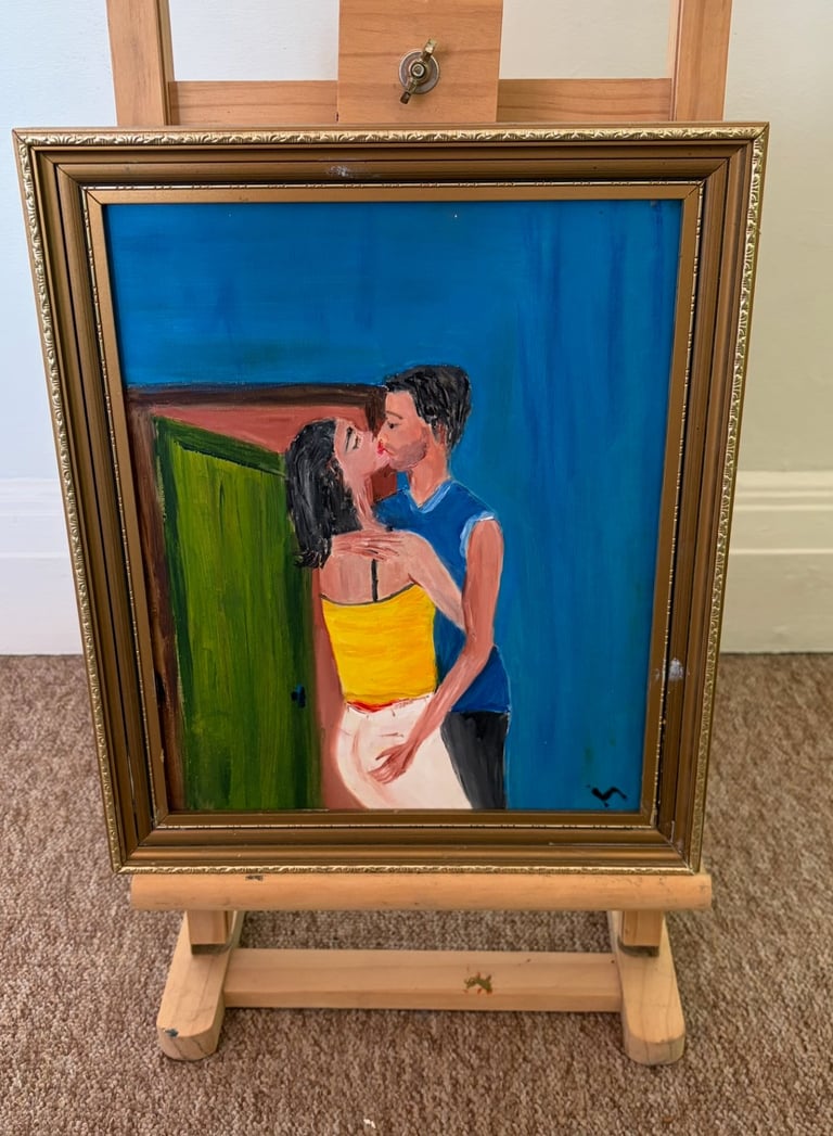 Framed painting on wooden easel depicting a woman in blue holding a yellow container against a blue background
