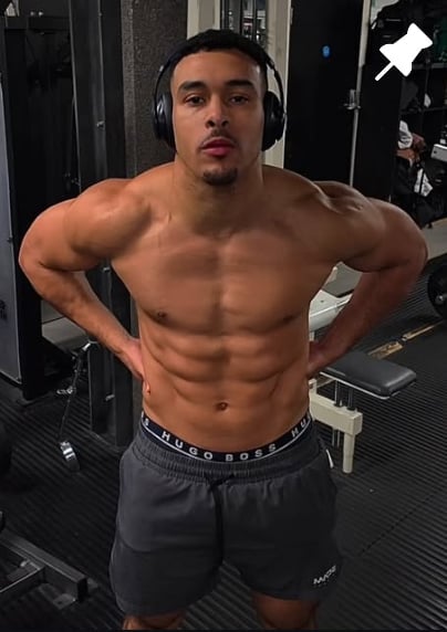 Shirtless muscular man posing in a gym